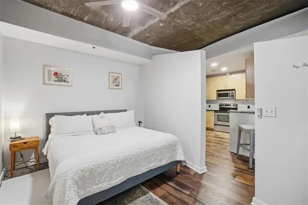a bedroom with a bed and a view of kitchen