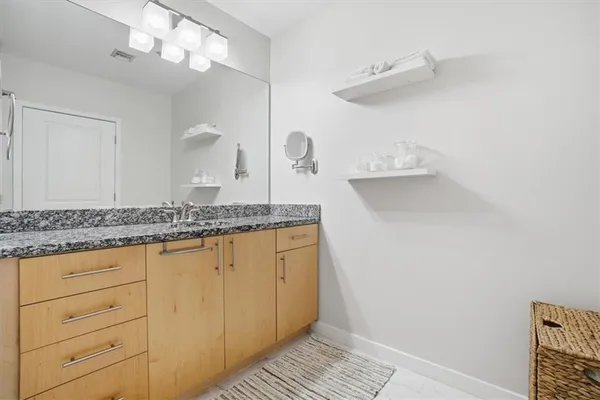 a bathroom with a granite countertop sink and a mirror