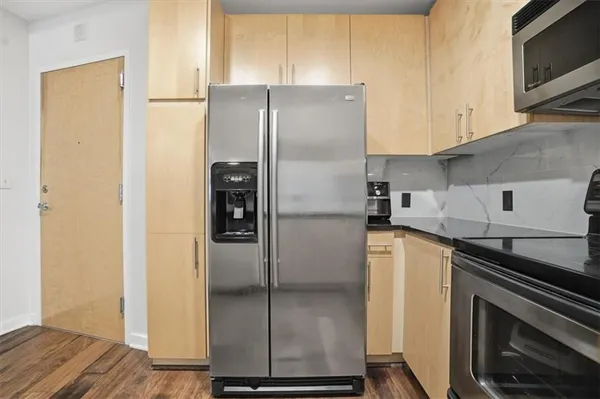 a kitchen with stainless steel appliances granite countertop a refrigerator and a stove top oven