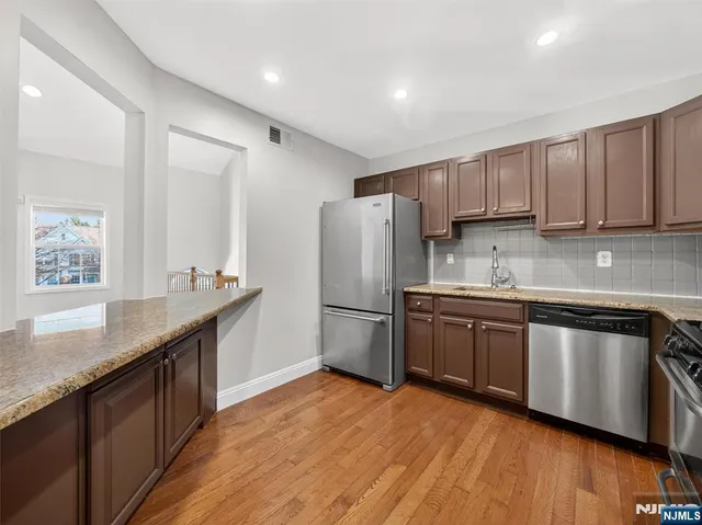 a bathroom with a granite countertop sink a toilet a mirror and shower