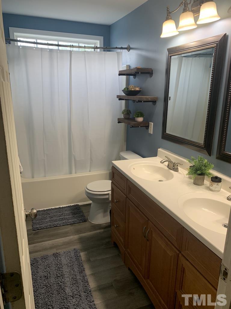 700 Hanska Way Raleigh, NC 27610 - Photo 3 of 3 Ensuite Master bath has dual vanities, laminate flooring with transom above shower/tub combo...