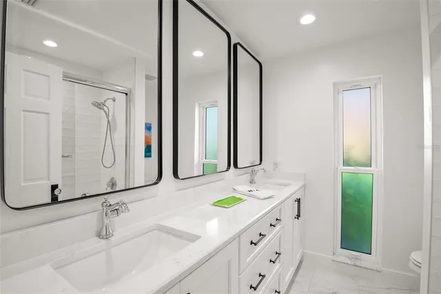 a bathroom with a granite countertop shower sink and mirror