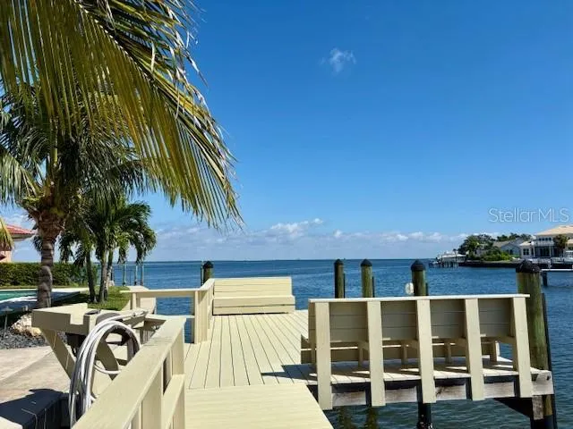 a view of a house with a yard and palm trees