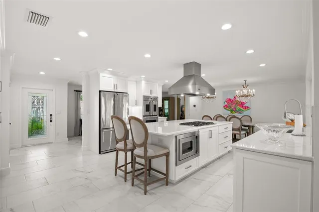 a dining room with furniture a fireplace and open kitchen view