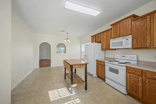 a kitchen with a refrigerator a stove a microwave and wooden cabinets