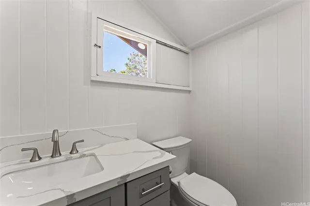 a bathroom with a toilet a sink and mirror