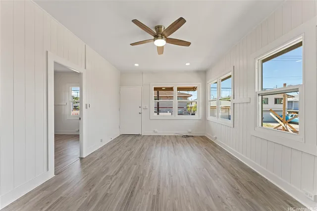 a view of an empty room with a window and wooden floor