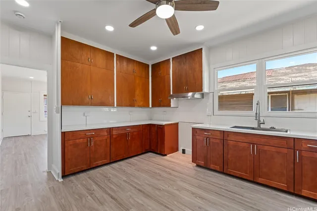 a large kitchen with stainless steel appliances granite countertop wooden cabinets a sink and dishwasher with wooden floor