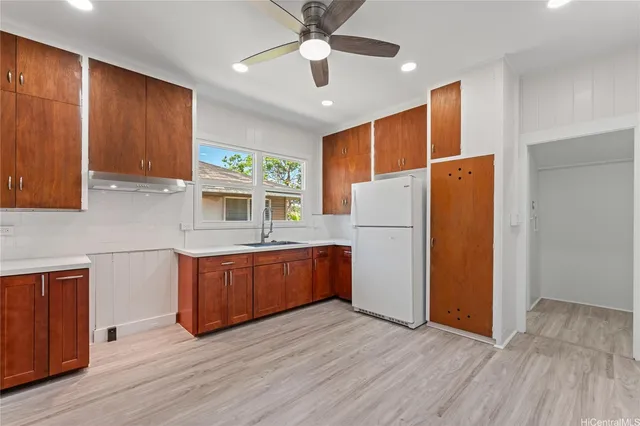 a kitchen with wooden floors and white cabinets