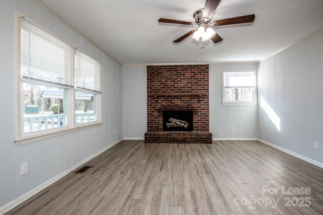 1159 Camp Creek Road Iron Station, NC 28080 - Photo 16 of 48 a view of empty room with fireplace and wooden floor
