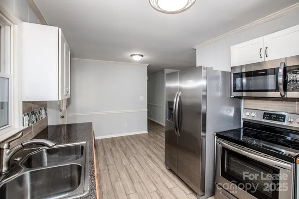 a kitchen with granite countertop white cabinets and white appliances