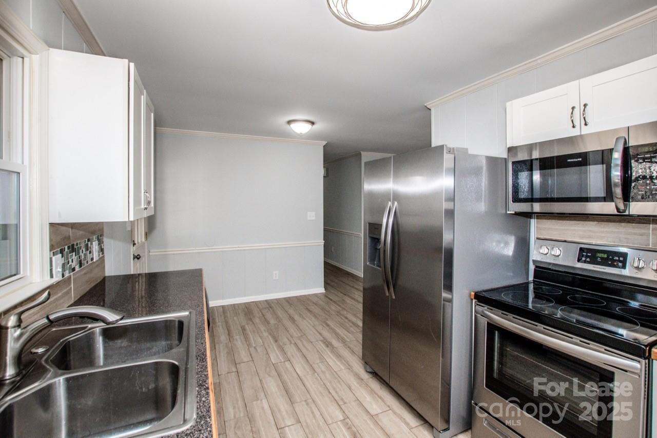 1159 Camp Creek Road Iron Station, NC 28080 - Photo 25 of 48 a kitchen with stainless steel appliances a stove a microwave and a refrigerator