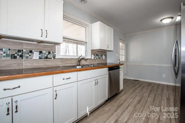 a kitchen with granite countertop stainless steel appliances a refrigerator and a stove top oven