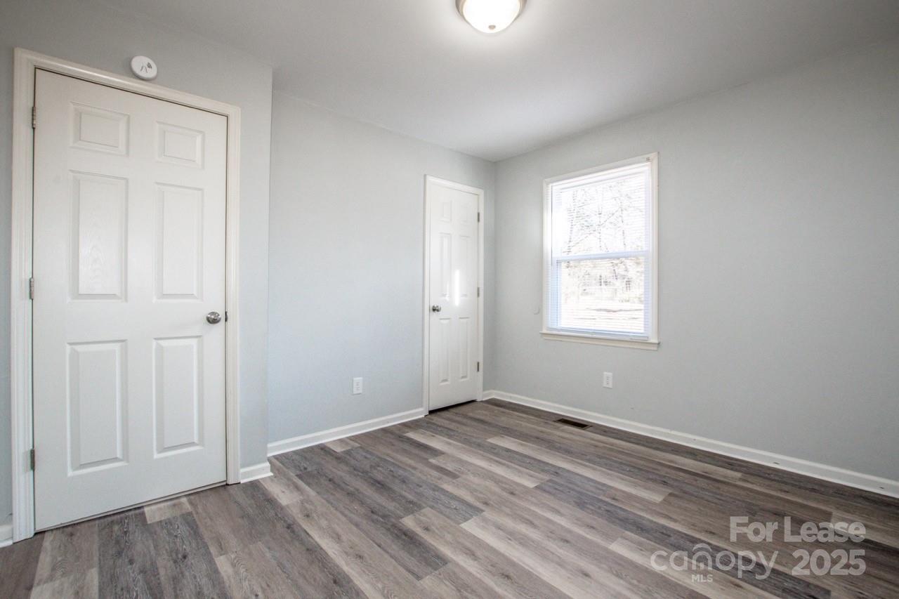 1159 Camp Creek Road Iron Station, NC 28080 - Photo 31 of 48 an empty room with wooden floor and windows