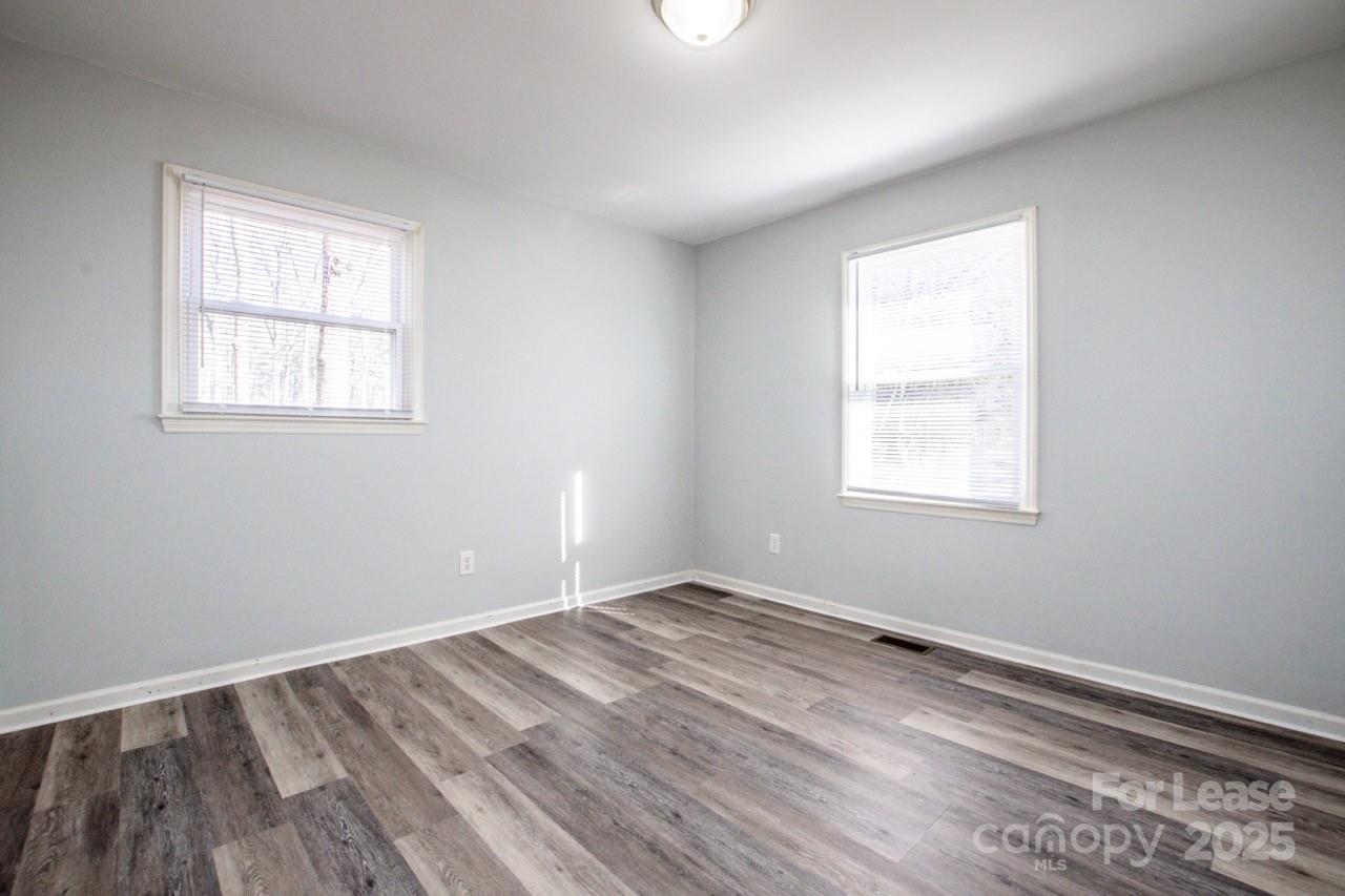1159 Camp Creek Road Iron Station, NC 28080 - Photo 35 of 48 an empty room with wooden floor and windows