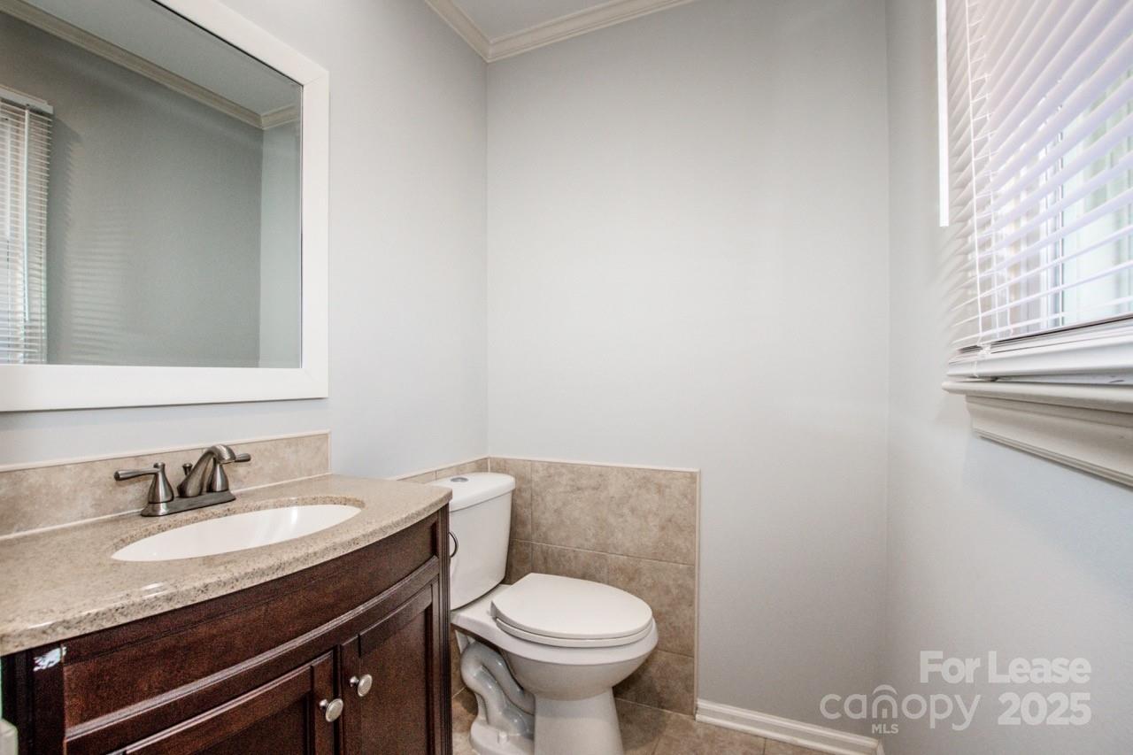 1159 Camp Creek Road Iron Station, NC 28080 - Photo 36 of 48 a bathroom with a granite countertop toilet sink and mirror