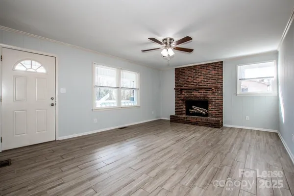 a view of empty room with wooden floor and fireplace