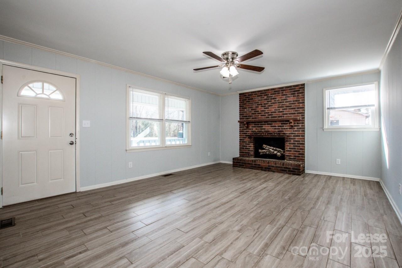 1159 Camp Creek Road Iron Station, NC 28080 - Photo 10 of 48 a view of empty room with wooden floor and fireplace