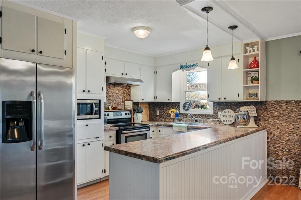 685 Kims Cove Road Canton, NC 28716 - Photo 16 of 43 a kitchen with stainless steel appliances granite countertop a sink a refrigerator and a stove
