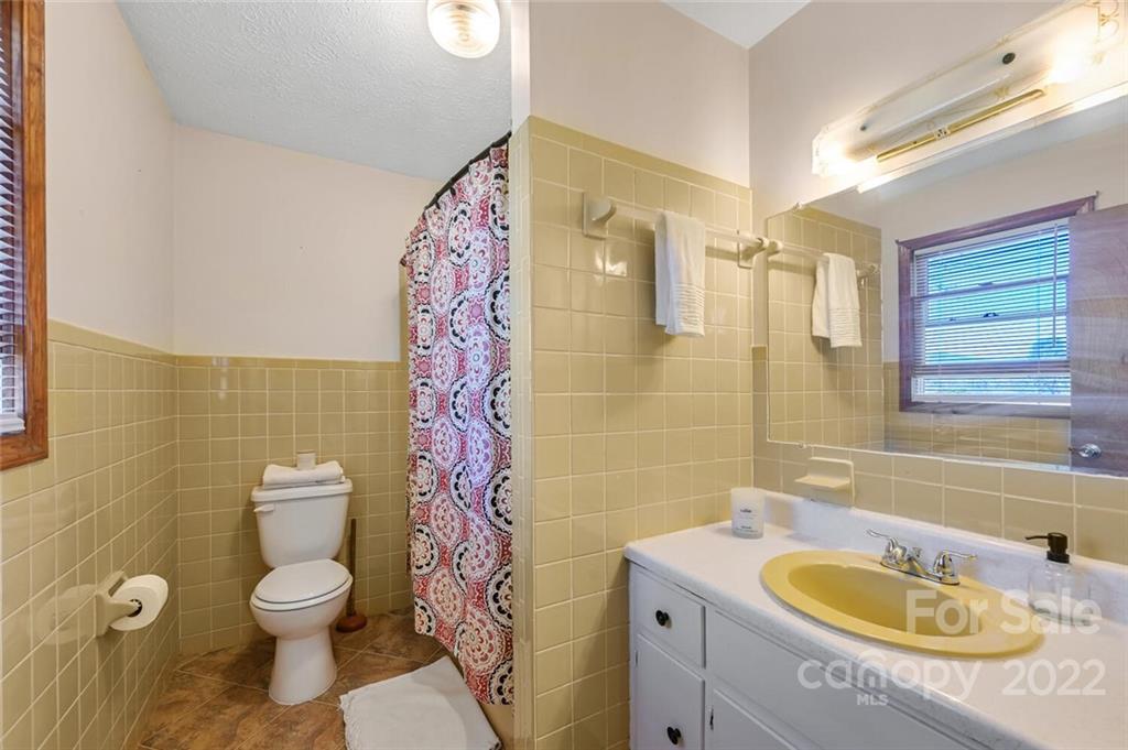 685 Kims Cove Road Canton, NC 28716 - Photo 18 of 43 a bathroom with a granite countertop toilet sink and mirror