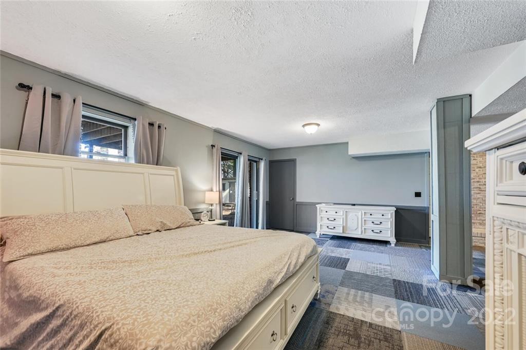 685 Kims Cove Road Canton, NC 28716 - Photo 26 of 43 a bedroom with a large bed and a tv