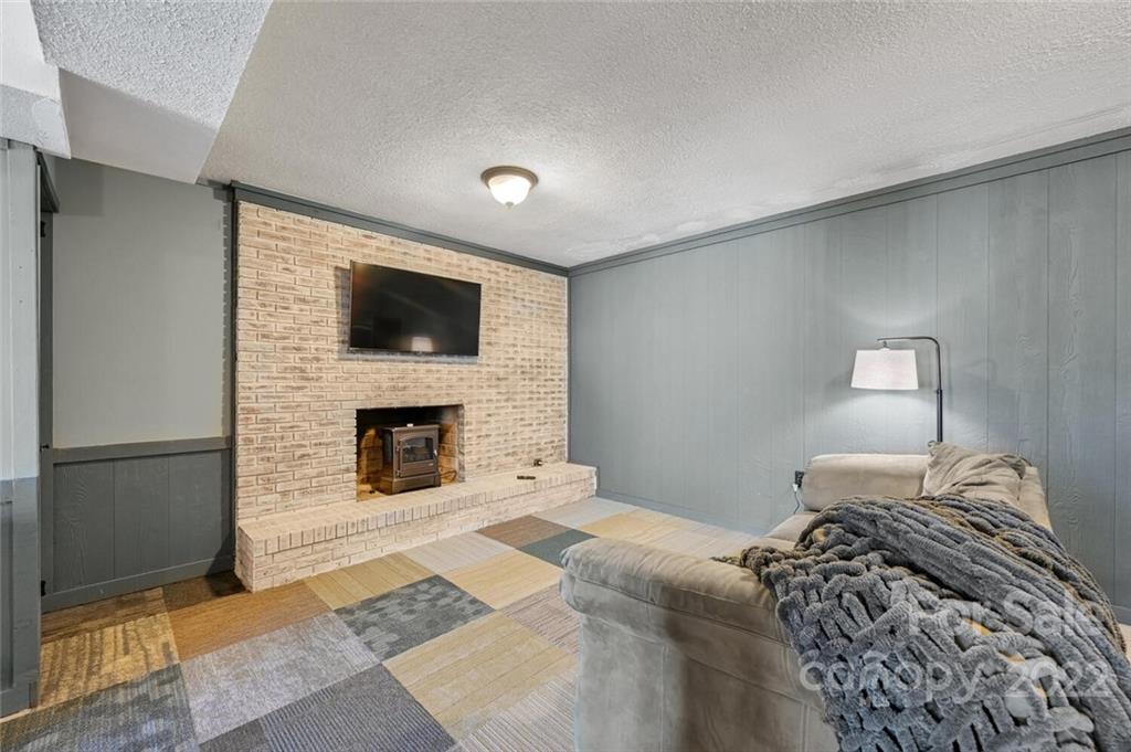 685 Kims Cove Road Canton, NC 28716 - Photo 27 of 43 a bedroom with a bed and a fireplace