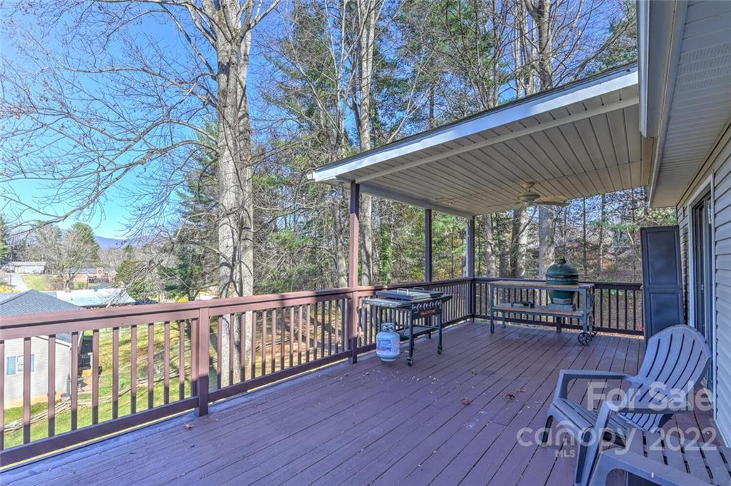 685 Kims Cove Road Canton, NC 28716 - Photo 34 of 43 a porch with wooden floor in front of a house with wooden fence