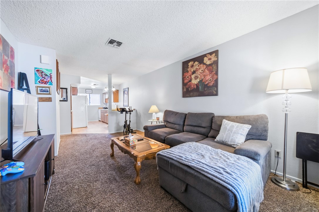 793 Baseline Road Bullhead City, AZ 86442 - Photo 12 of 49 Carpeted living area featuring light gray walls and a textured ceiling