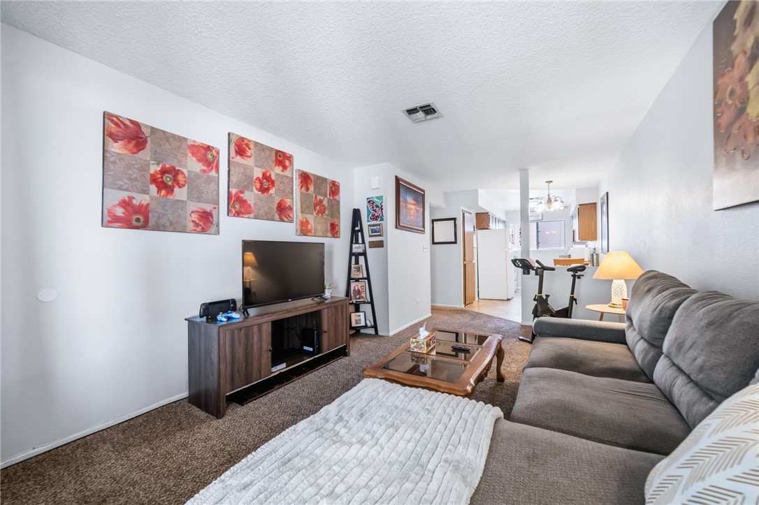 793 Baseline Road Bullhead City, AZ 86442 - Photo 14 of 49 Carpeted living area with white walls and a textured ceiling