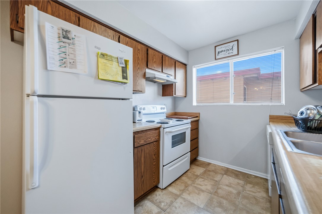 793 Baseline Road Bullhead City, AZ 86442 - Photo 18 of 49 Kitchen featuring wood-finish cabinetry, white appliances, and a double basin sink