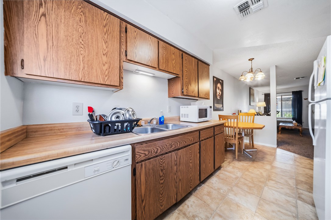 793 Baseline Road Bullhead City, AZ 86442 - Photo 19 of 49 Kitchen featuring wood-finish cabinetry, a built-in dishwasher, and a double basin sink