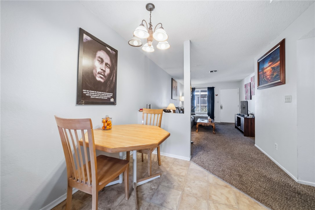 793 Baseline Road Bullhead City, AZ 86442 - Photo 22 of 49 Dining area featuring a four-light chandelier, light-toned wall paint, and tile flooring