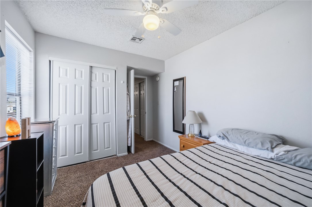 793 Baseline Road Bullhead City, AZ 86442 - Photo 23 of 49 Bedroom featuring light gray walls, carpet flooring, a window with horizontal blinds, a ceiling fan with integrated lighting, and a bi-fold closet door