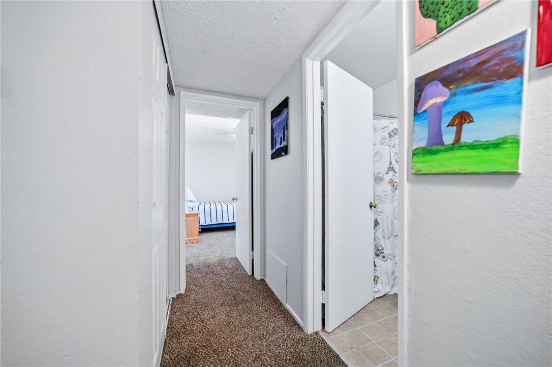 793 Baseline Road Bullhead City, AZ 86442 - Photo 24 of 49 Carpeted hallway with a textured ceiling, white walls, and white trim