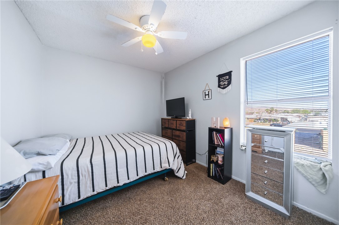 793 Baseline Road Bullhead City, AZ 86442 - Photo 25 of 49 Light gray walls featuring carpet flooring and a ceiling fan with integrated lighting