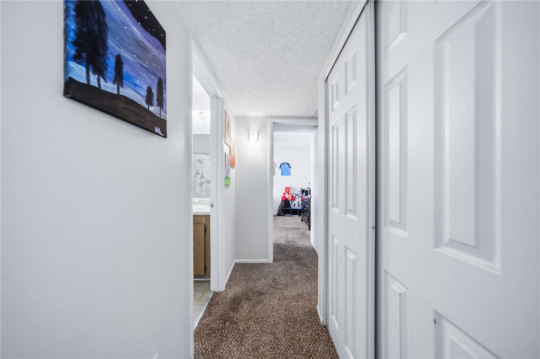 793 Baseline Road Bullhead City, AZ 86442 - Photo 26 of 49 Carpeted hallway featuring white walls and a textured ceiling