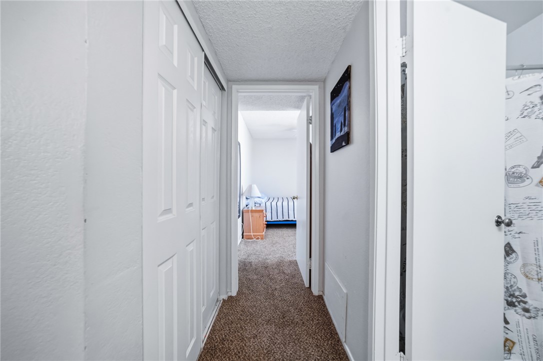 793 Baseline Road Bullhead City, AZ 86442 - Photo 27 of 49 Carpeted hallway with white walls and a textured ceiling