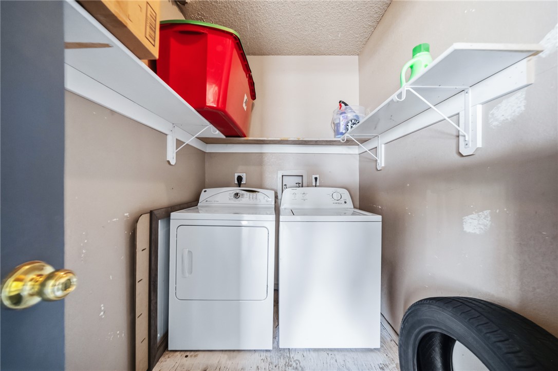 793 Baseline Road Bullhead City, AZ 86442 - Photo 33 of 49 Dedicated laundry area featuring a white washing machine and dryer, overhead shelving for storage, and a light-toned ceiling