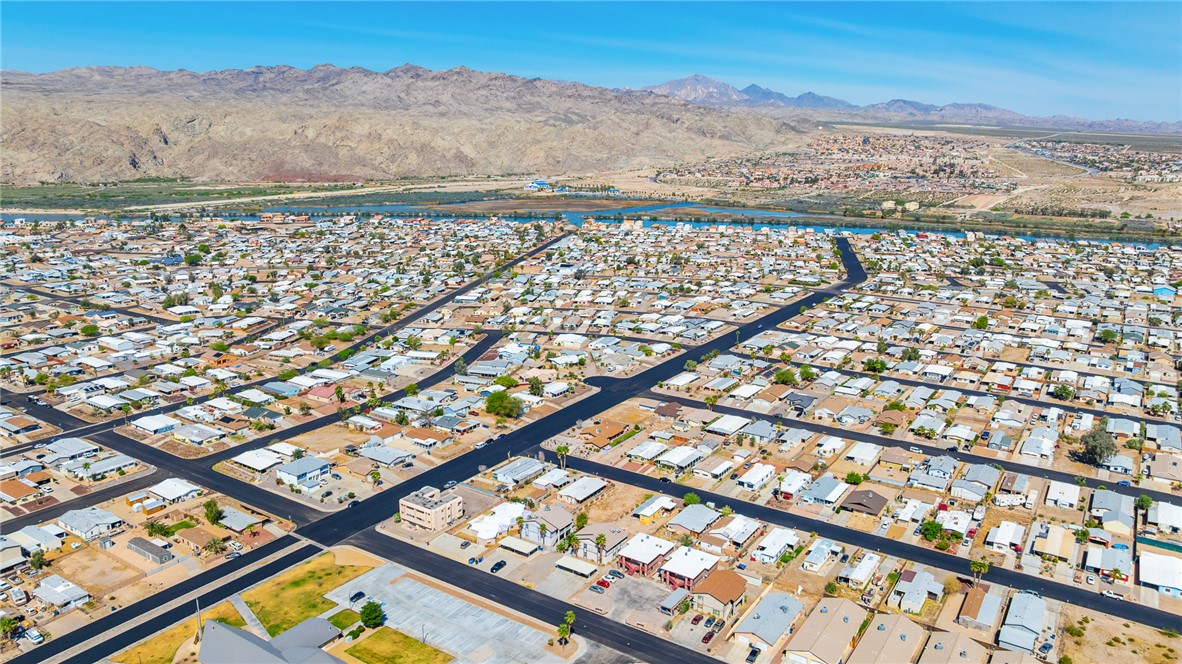 793 Baseline Road Bullhead City, AZ 86442 - Photo 37 of 49 Expansive aerial perspective showcasing a residential grid with established properties, bordered by distant mountains and a prominent body of water