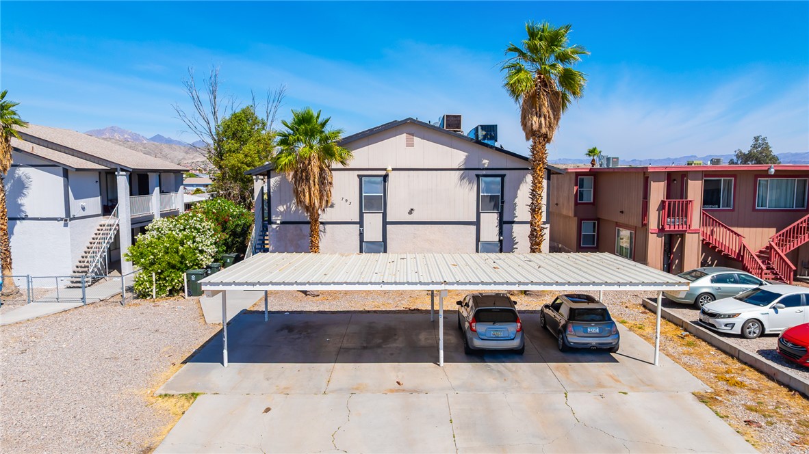 793 Baseline Road Bullhead City, AZ 86442 - Photo 43 of 49 Property exterior featuring a carport, two residential buildings, and mountainous terrain in the distance