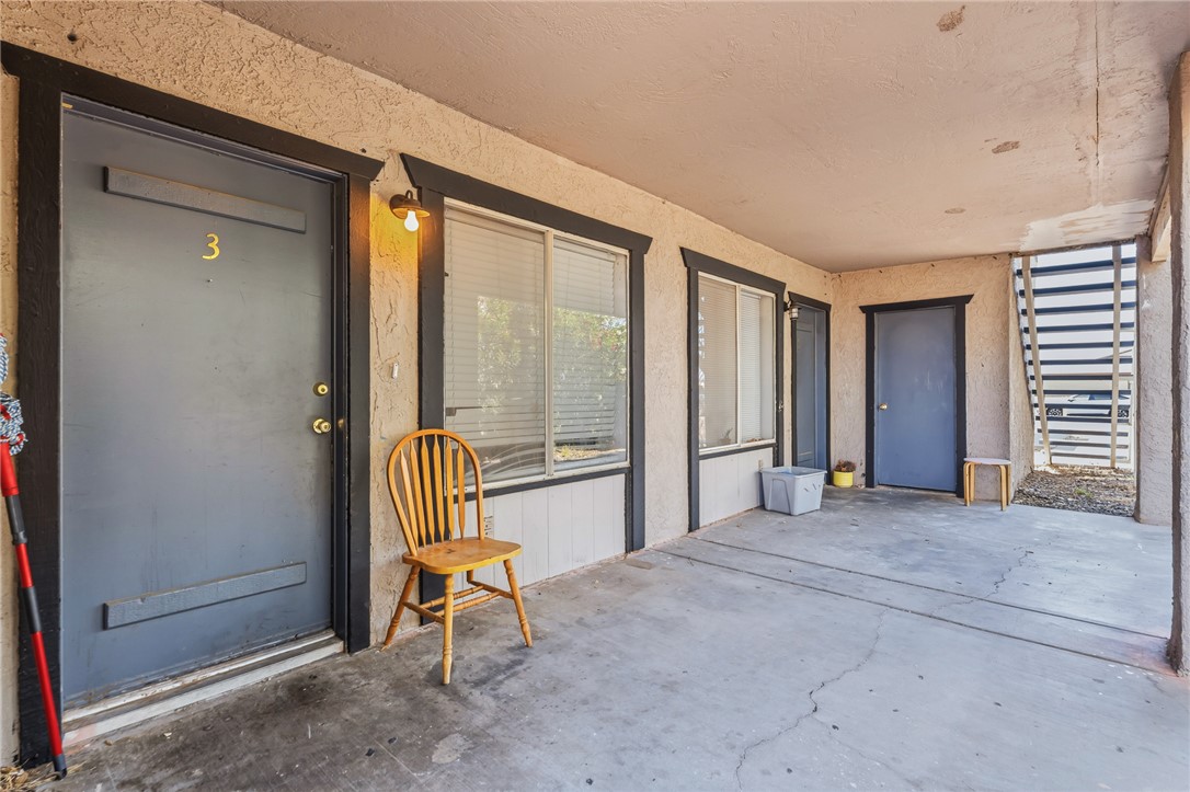 793 Baseline Road Bullhead City, AZ 86442 - Photo 7 of 49 Covered exterior patio featuring a concrete surface, stucco walls, and multiple entry doors