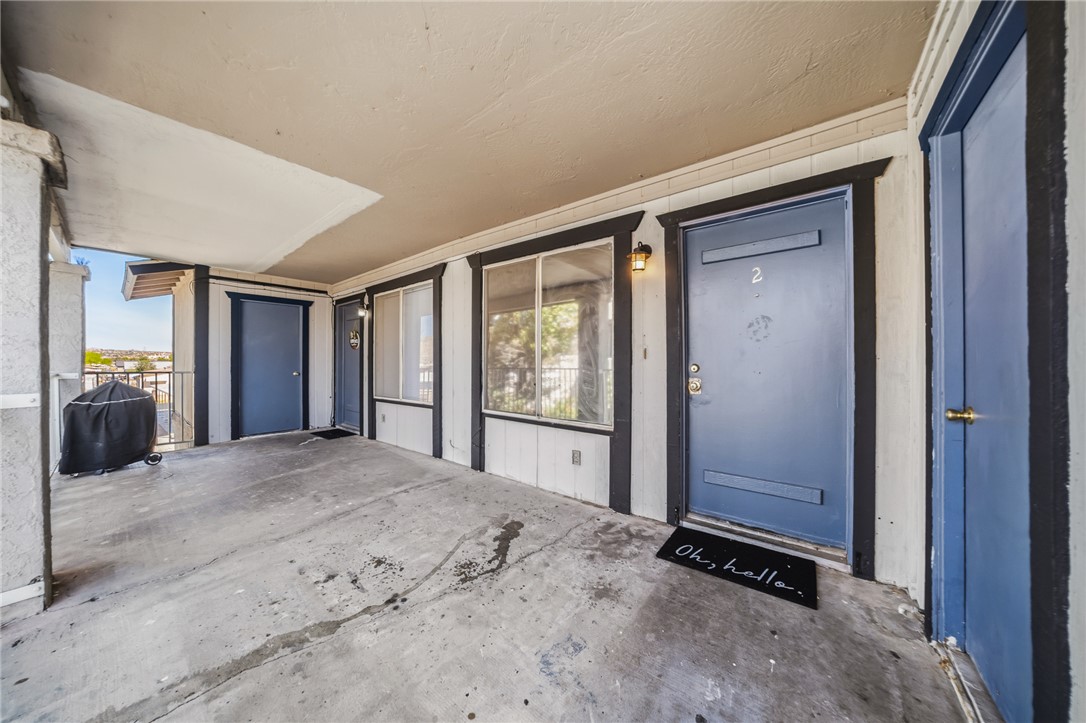793 Baseline Road Bullhead City, AZ 86442 - Photo 8 of 49 Covered concrete patio with multiple entry points, featuring a metal railing and distant city views