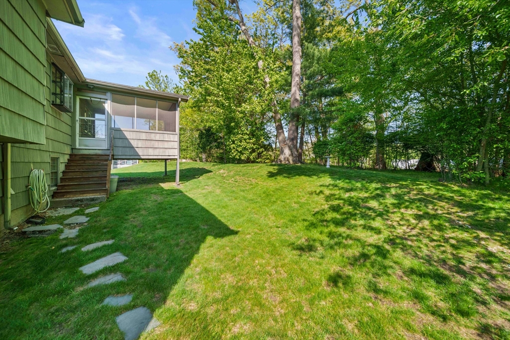 129 Devon Road Norwood, MA 02062 - Photo 27 of 32 a view of a backyard with table and chairs and large trees