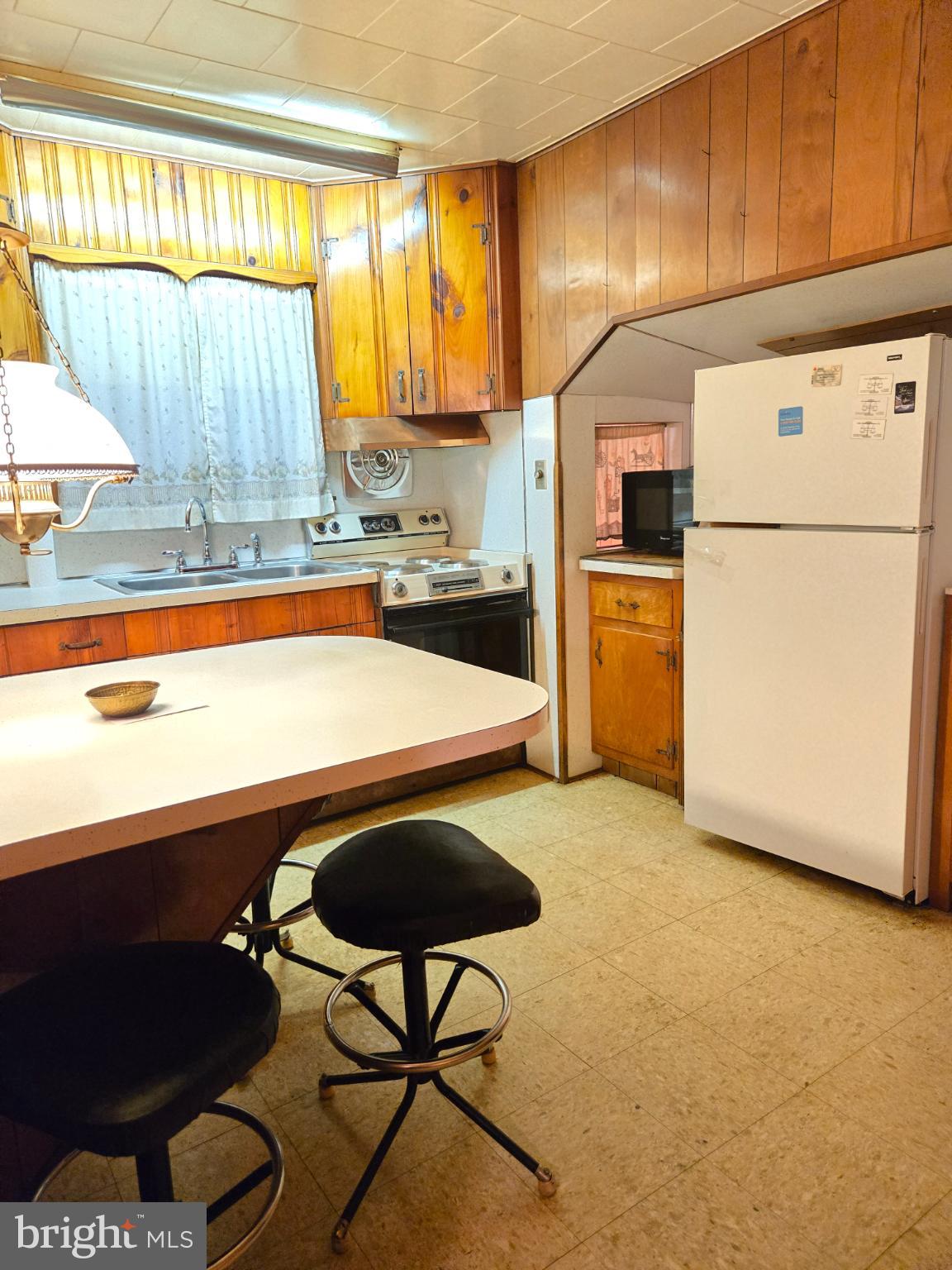 1003 Church Road Oreland, PA 19075 - Photo 7 of 18 a kitchen with stainless steel appliances granite countertop a sink refrigerator and cabinets