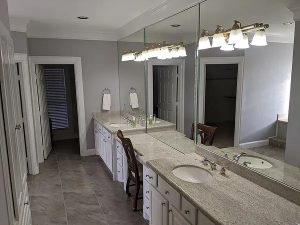 a bathroom with a granite countertop double vanity sink and a mirror