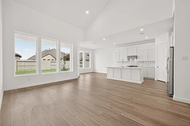 an empty room with wooden floor and window