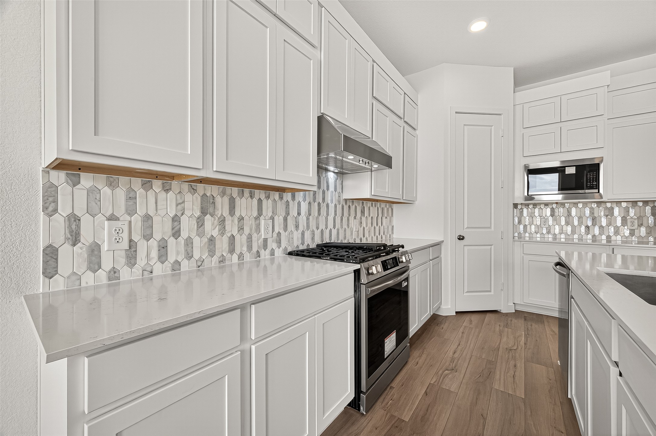 2419 Hazel Berry Street Manvel, TX 77578 - Photo 16 of 50 a kitchen with white cabinets and appliances