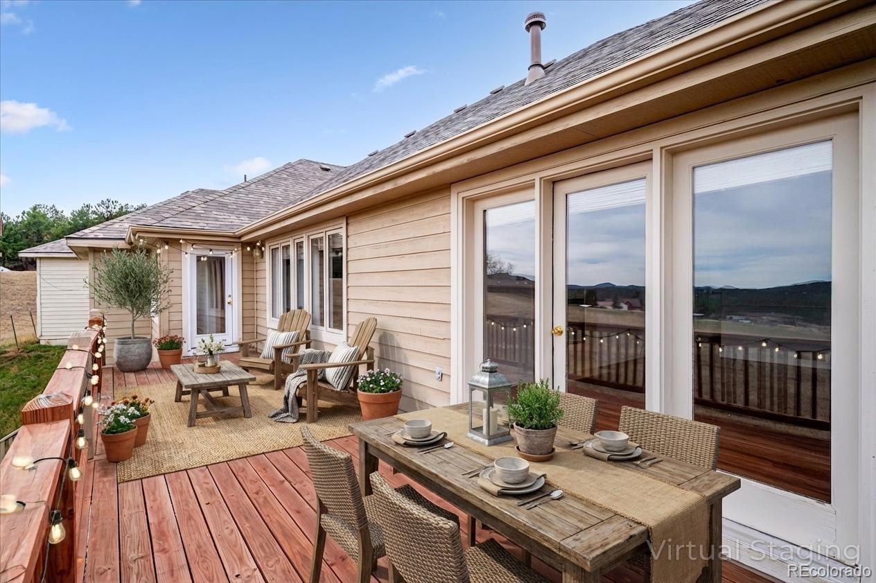 6320 Valley Lane Morrison, CO 80465 - Photo 24 of 28 a view of a patio with lawn chairs floor to ceiling window and wooden floor