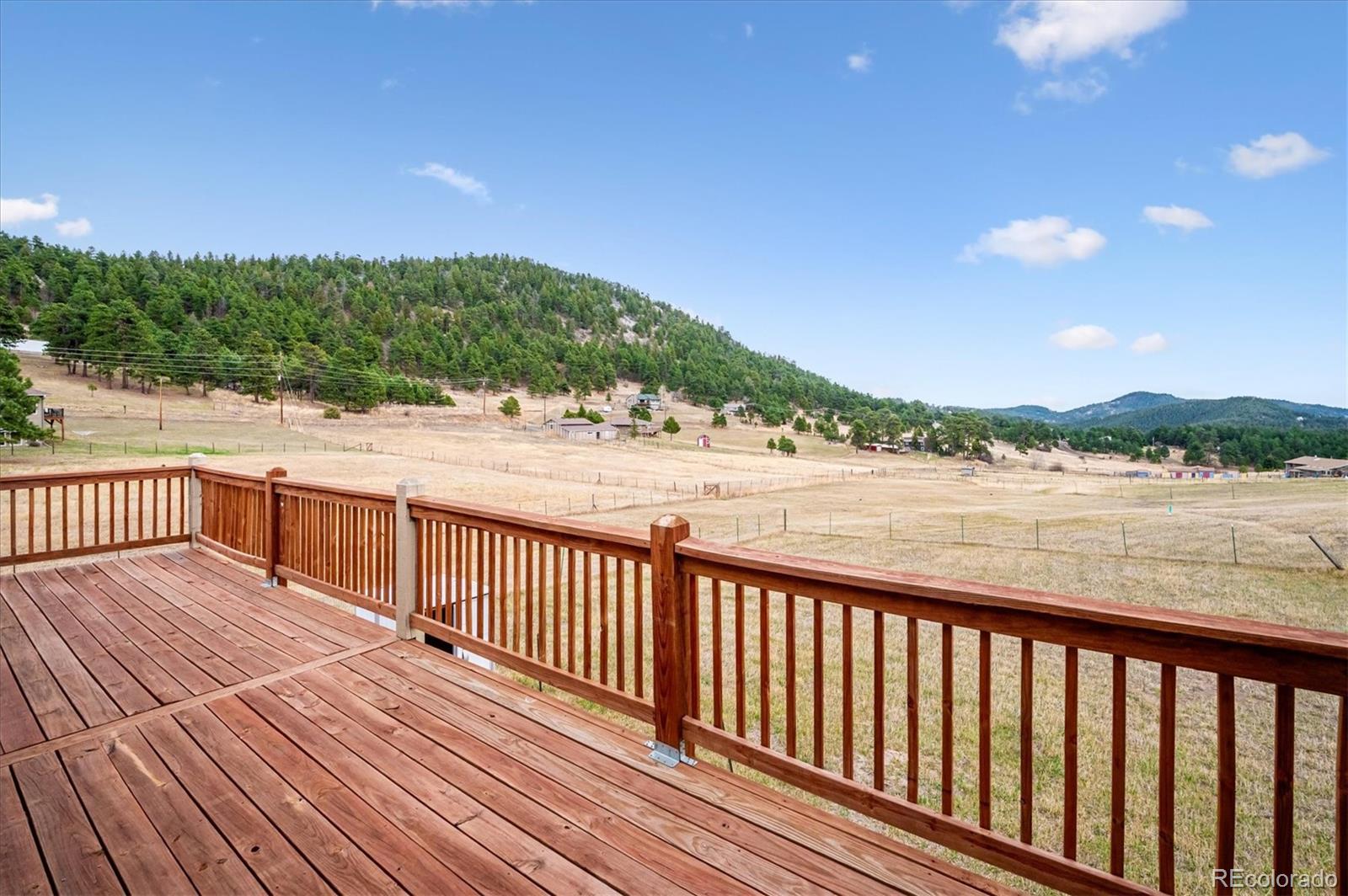 6320 Valley Lane Morrison, CO 80465 - Photo 25 of 28 a balcony with wooden floor and yard in the back