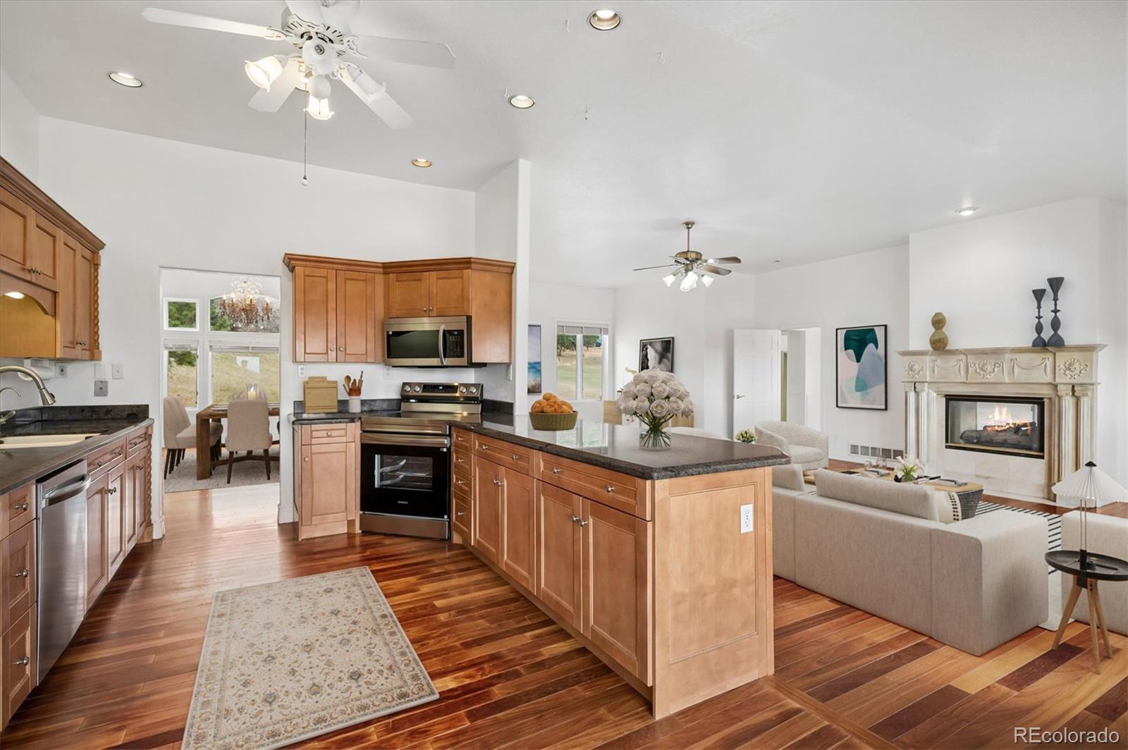 6320 Valley Lane Morrison, CO 80465 - Photo 8 of 28 a kitchen with stainless steel appliances granite countertop a stove top oven a sink dishwasher a dining table and chairs with wooden floor